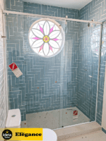 Box Elegance de vidro temperado incolor com estrutura metálica e roldanas aparentes na cor branco, sendo 1 folha fixa e 1 porta de correr.