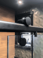 Box Elegance de vidro temperado incolor com estrutura metálica e roldanas aparentes na cor preta, sendo 1 folha fixa e 1 porta de correr.